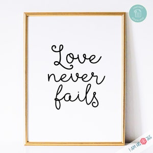 May include: A printable wall art design with a gold frame. The design features the text "Love never fails" in a black cursive font.
