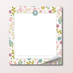 May include: A floral-patterned notepad with a white interior and a curled corner. The border features pink, blue, and yellow flowers with green leaves on a cream background. A blue cross is at the top, and the text "With God all things are possible - Matthew 19:26" is at the bottom.
