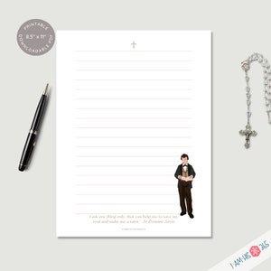 Close up of blank lined printable stationery page with St Dominic Savio in the bottom right corner and corresponding saint quote on the bottom of the page. A small cross is shown on the top of each paper. A pen and rosary are shown for size context.