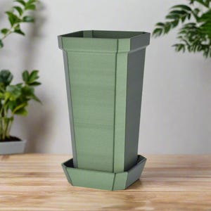 May include: A green plastic planter with a square top and a square base. The planter has a textured surface and a matching saucer.