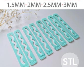 May include: A collection of light teal clay thickness guides, labeled with measurements from 1.5mm to 3mm. The guides have a wavy design and are arranged on a white surface. The text "CLAY THICKNESS GUIDES" is at the top.