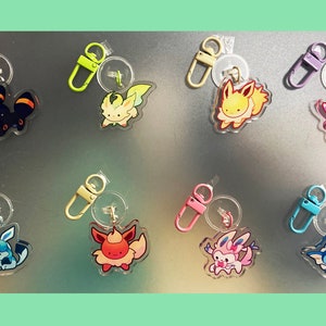 Puede incluir: Ocho llaveros diferentes con varios personajes de Pokémon. Cada llavero tiene un dije de plástico transparente con una imagen de dibujos animados de un Pokémon, unido a un anillo de metal y un gancho de metal. Los personajes de Pokémon incluyen Eevee, Vaporeon, Jolteon, Flareon, Umbreon, Espeon, Leafeon y Glaceon.