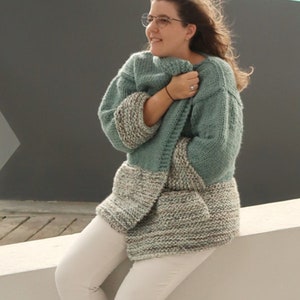 May include: A printable PDF knitting pattern for a teal and grey cardigan. The pattern is available for download on the website knittingwithchopsticks.com.