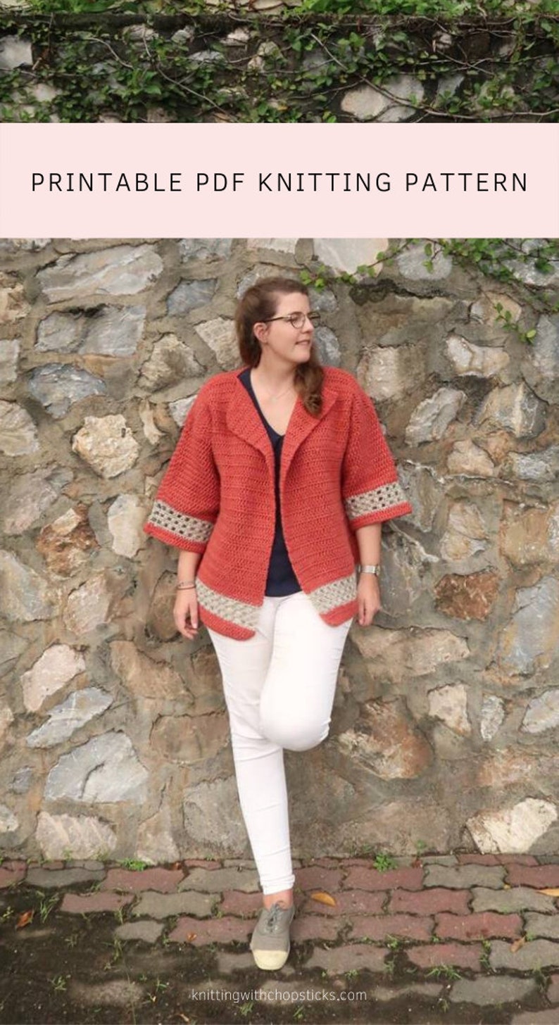 Peut inclure: Une femme portant un cardigan en crochet de couleur corail avec une bordure en crochet blanc. Le cardigan a un col ch&acirc;le et des manches trois-quarts. Elle se tient devant un mur de pierre avec des vignes vertes qui poussent dessus. Le texte "PRINTABLE PDF KNITTING PATTERN" est en haut de l'image.