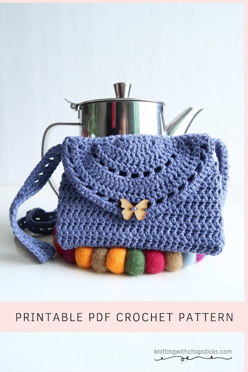 May include: A crocheted blue purse with a wooden butterfly embellishment. The purse is sitting on a colorful felt coaster.  Printable PDF Crochet Pattern.