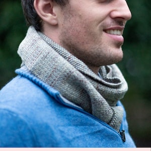 Puede incluir: Un hombre con un suéter azul y una bufanda gris y marrón. La imagen incluye el texto "Patrón de tejido PDF imprimible" y el sitio web "knittingwithchopsticks.com".