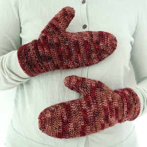 May include: A pair of red and brown crocheted mittens with a striped pattern.