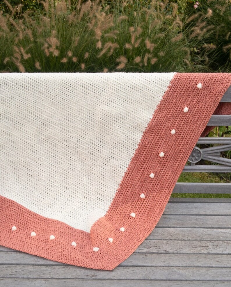 crochet blanket thrown over bench showing 2 color border