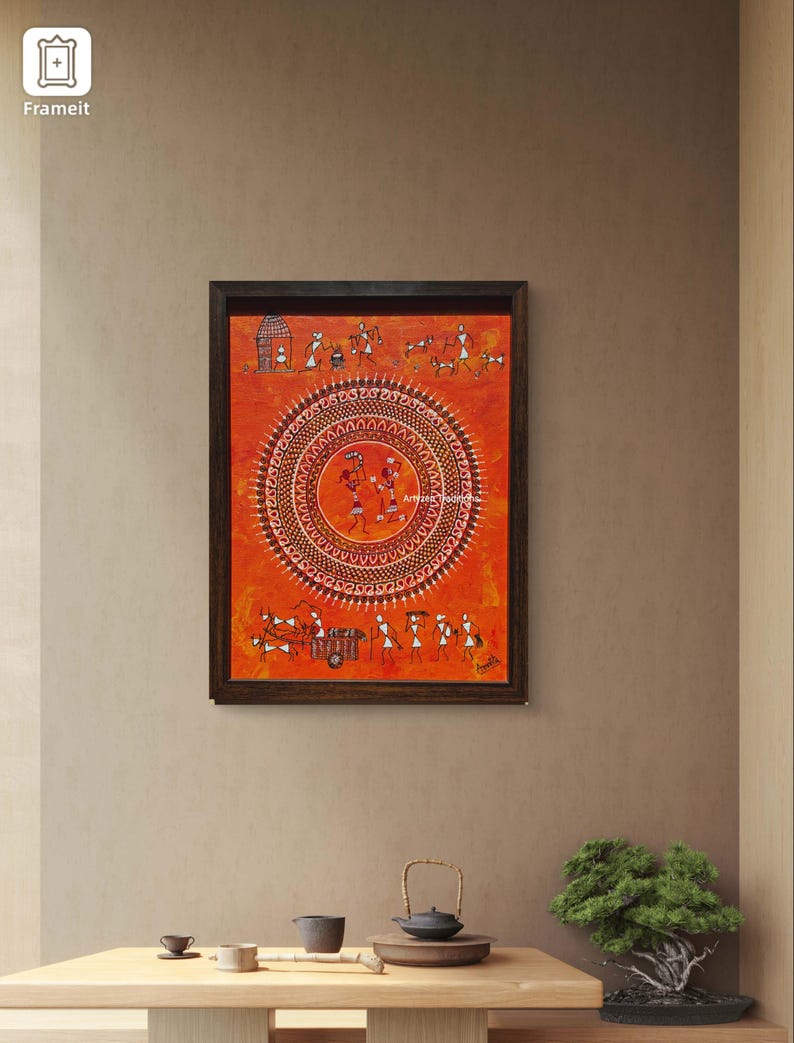 Pu&ograve; includere: Un dipinto rettangolare incorniciato con uno sfondo arancione vibrante e complessi disegni a linee bianche. L'opera mostra un motivo centrale a mandala circolare circondato da piccole figure di persone, animali e capanne.