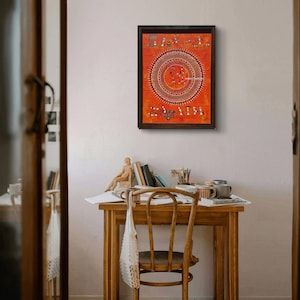 Pu&ograve; includere: Un'opera d'arte da parete rettangolare incorniciata caratterizzata da uno sfondo arancione vibrante con intricati disegni a linee bianche in stile tribale. L'opera mostra un grande motivo mandala circolare centrale circondato da piccole figure di persone e animali.
