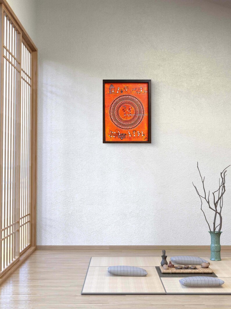 Pu&ograve; includere: Un'opera d'arte murale rettangolare caratterizzata da uno sfondo arancione vibrante con intricati motivi in bianco e nero in stile tribale. L'opera mostra un grande motivo circolare centrale circondato da piccole figure e strutture in una cornice scura.