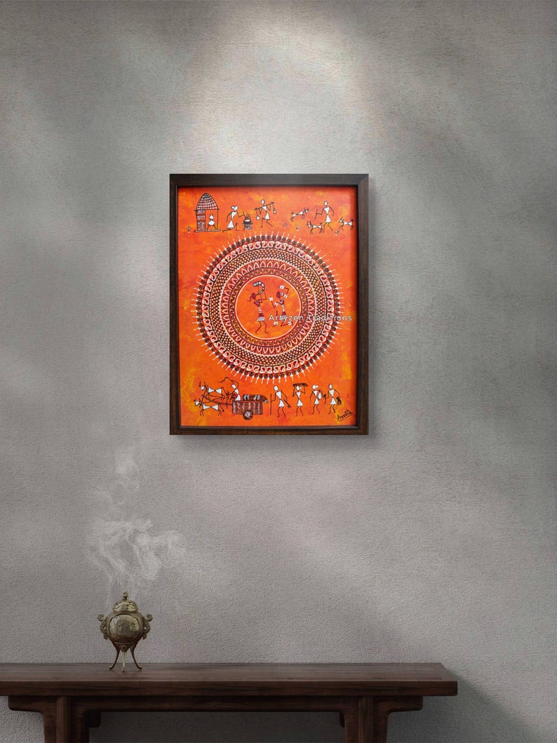 Pu&ograve; includere: Un dipinto rettangolare incorniciato con uno sfondo arancione vibrante e intricate figure bianche in stile Warli. Il design centrale &egrave; un grande motivo a mandala circolare con piccole figure che danzano all'interno, circondato da scene di vita quotidiana.
