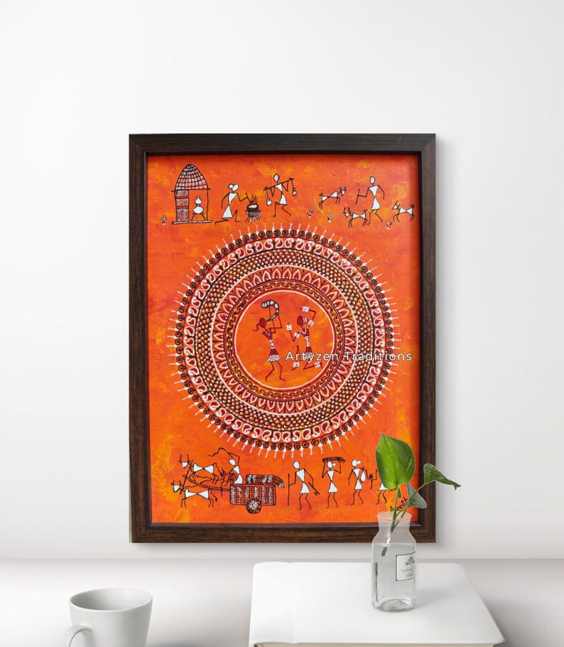 Pu&ograve; includere: Un dipinto rettangolare incorniciato con sfondo arancione che presenta figure stilizzate bianche e un motivo a mandala circolare centrale. L'opera include raffigurazioni di una capanna, animali, un carro e persone, con il testo Artyzen Traditions.