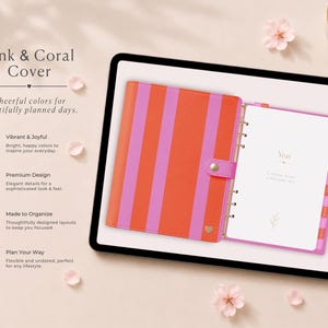 Puede incluir: Una agenda con cubierta de rayas rosas y coral, con un emblema de corazón dorado y cierre a presión. El interior abierto muestra páginas blancas con texto dorado que dice Year, A fresh start, a focused you y pestañas laterales.
