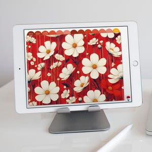 May include: A white tablet with a red and white floral pattern displayed on the screen. The tablet is on a silver stand.