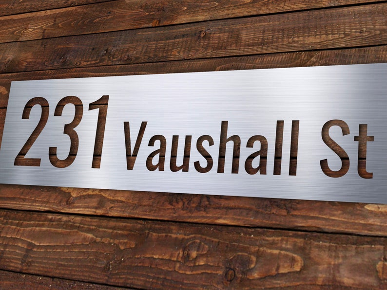 May include: A silver metal house number sign with the number 231 and the street name Vauxhall St cut out.