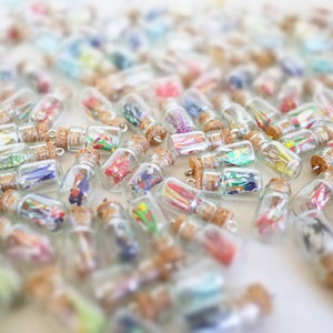 An array of miniature glass bottles filled with colorful origami cranes, sealed with corks, creating a vibrant mosaic of potential personalized gifts for special occasions.