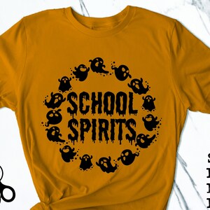 May include: A mustard yellow t-shirt with a black graphic of ghosts surrounding the text "SCHOOL SPIRITS".