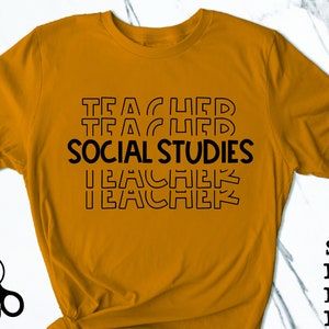 Op de afbeelding: Een mosterdgeel T-shirt met de tekst "TEACHER SOCIAL STUDIES TEACHER" in zwarte omrande letters.