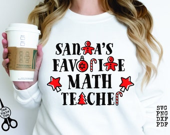Op de afbeelding: Witte longsleeve met rode sterren en een gingerbread man ontwerp. De tekst op het shirt luidt "Santa's favoriete wiskundeleraar" met een snoepstok.