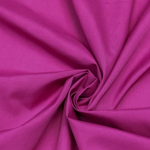 May include: A close-up of a vibrant magenta fabric, showing the soft, smooth texture and flowing folds.
