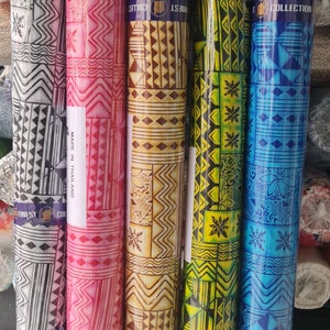 May include: Four rolls of fabric with geometric patterns in black and white, pink and white, brown and white, and blue and white. The fabric is labeled "Finest Collection" and "Made in Thailand".