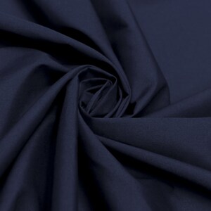 May include: A close-up of a dark blue fabric, showing the texture and folds of the material.