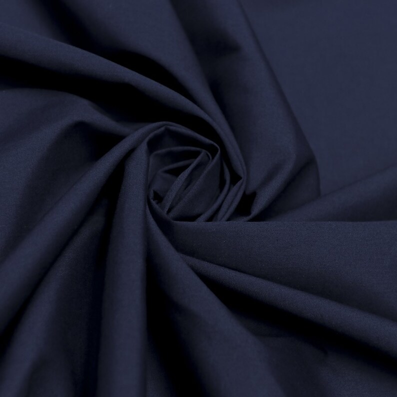 May include: A close-up of a dark blue fabric, showing the texture and folds of the material.