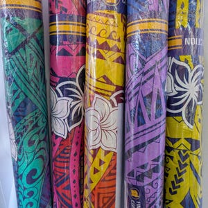 May include: Five rolls of fabric with different colorful Polynesian patterns. The fabric is wrapped in plastic and has a label that says "Finest Collection".