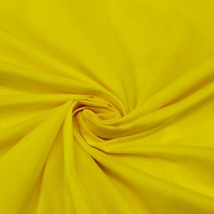 May include: A bright yellow fabric with a smooth texture. The fabric is folded and draped, creating soft folds and curves.