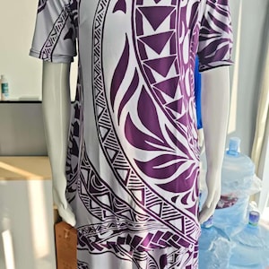May include: A white and purple patterned shirt and skirt set. The shirt has short sleeves and a round neckline. The skirt is long and flowy. The pattern is a traditional Polynesian design.
