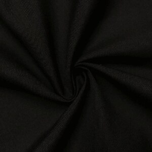 May include: Black fabric with a textured weave. The fabric is folded and draped, showing its soft texture.
