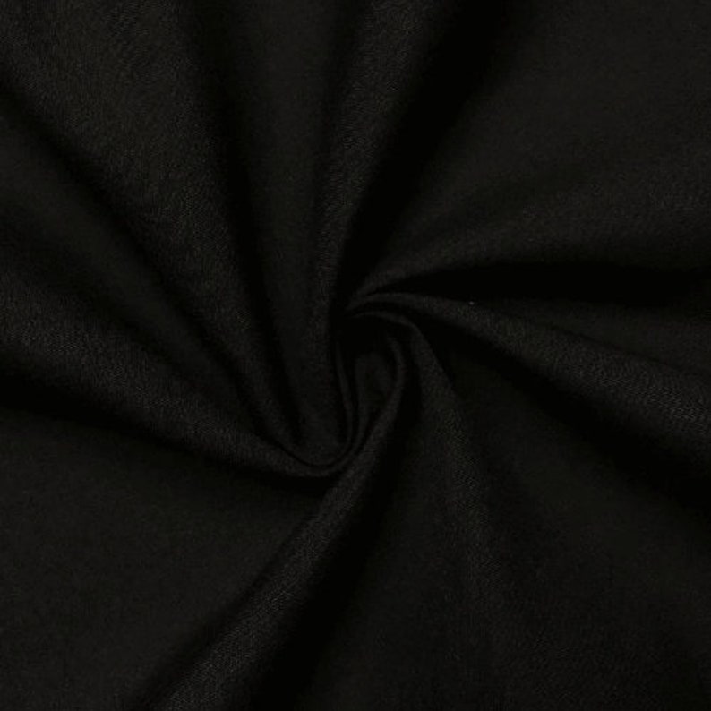 May include: Black fabric with a textured weave. The fabric is folded and draped, showing its soft texture.