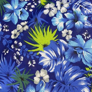 May include: A blue and white floral fabric with a tropical print. The fabric features large blue flowers, white flowers, and green leaves.