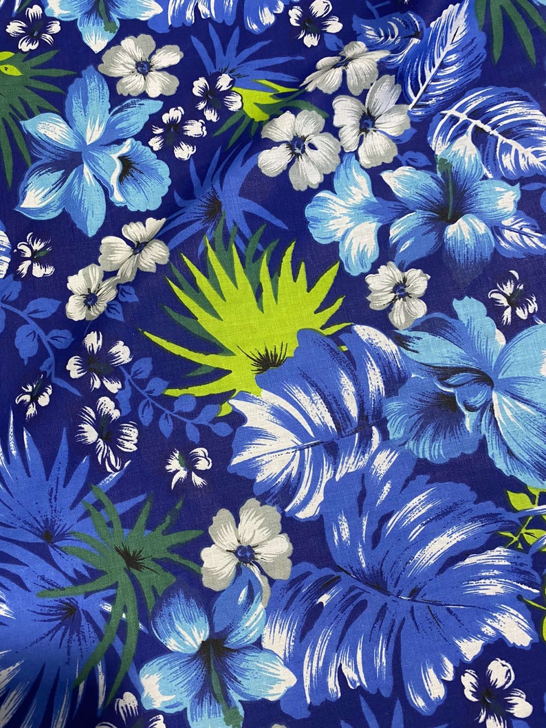 May include: A blue and white floral fabric with a tropical print. The fabric features large blue flowers, white flowers, and green leaves.