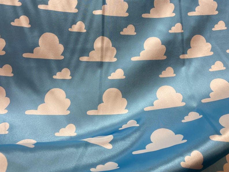Puede incluir: Una tela azul con un patr&oacute;n de nubes blancas. Las nubes est&aacute;n en un patr&oacute;n repetitivo y todas son del mismo tama&ntilde;o y forma.