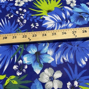 May include: Blue fabric with a tropical print featuring white and blue flowers, green leaves, and a ruler measuring 20 to 28 inches.