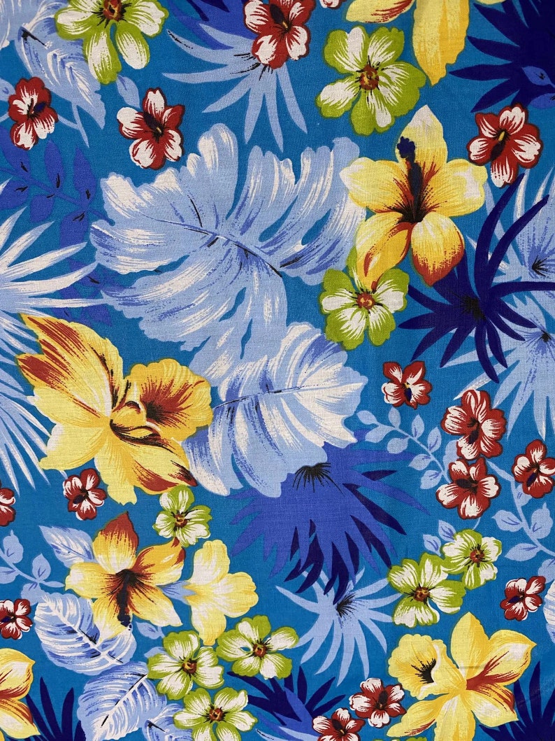 May include: A blue fabric with a tropical print featuring yellow, red, and white flowers, blue and white leaves, and a blue background.