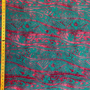 May include: Teal and pink fabric with a repeating pattern of waves and floral designs. The fabric has a distressed look, giving it a vintage feel.