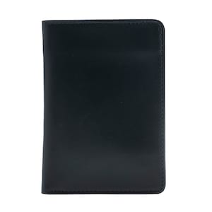 May include: A black leather passport holder. The cover is smooth and rectangular with rounded corners. The edges are neatly stitched with a contrasting thread. The holder is designed to protect and carry travel documents.