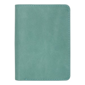 May include: A teal-colored, rectangular notebook or journal with a soft, textured cover. The edges are neatly stitched with a matching teal thread. The cover appears to be made of a suede or faux-suede material.