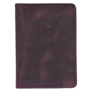 May include: A dark purple leather journal with a textured surface. The edges are stitched with purple thread. The journal is rectangular and appears to be closed.