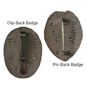 May include: Two badges with textured, oval-shaped faces. One has a clip back, the other a pin back. Both are a dark, metallic color with small, silver-colored accents. Text on the image reads "Clip Back Badge" and "Pin Back Badge".