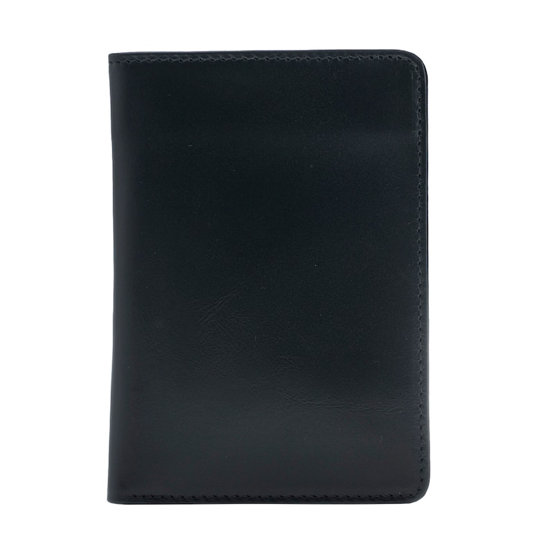 May include: A black leather passport holder. The cover is smooth and rectangular with rounded corners. The edges are neatly stitched with a contrasting thread. The holder is designed to protect and carry travel documents.