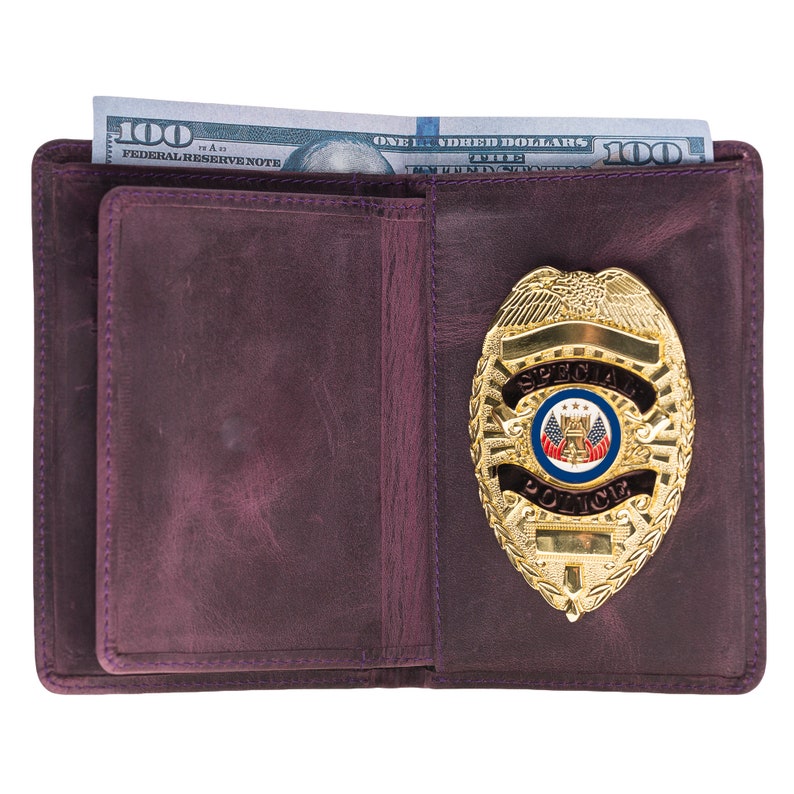 May include: A purple leather wallet with a gold-colored Special Police badge and a hundred-dollar bill. The badge has a detailed design with the words "SPECIAL POLICE" and a circular emblem. The wallet is open, revealing the interior.