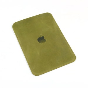 May include: A green leather case with an Apple logo embossed on the front.