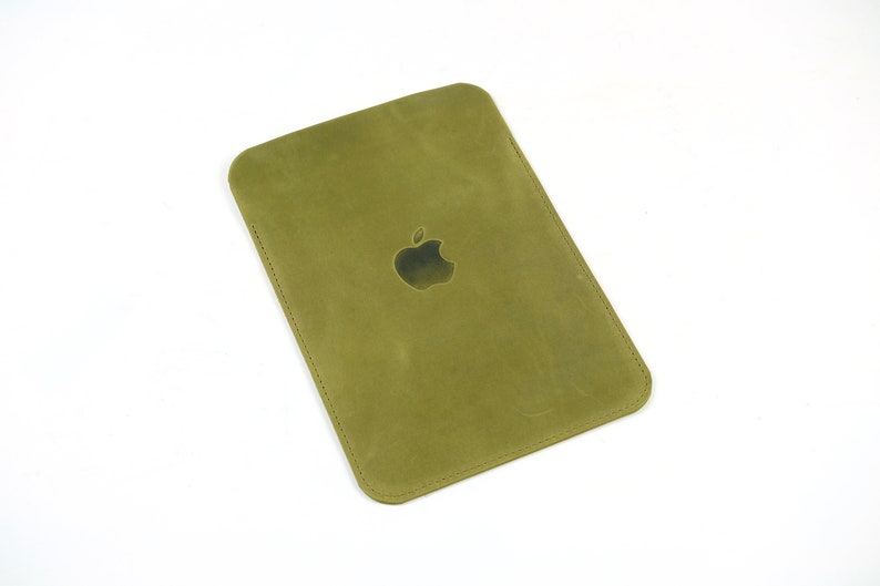 May include: A green leather case with an Apple logo embossed on the front.