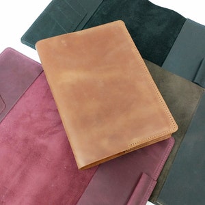May include: Three leather-bound journals in different colors: burgundy, brown, and black. Each journal has a suede interior.