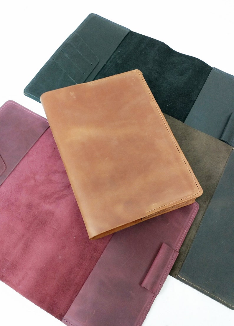 May include: Three leather-bound journals in different colors: burgundy, brown, and black. Each journal has a suede interior.