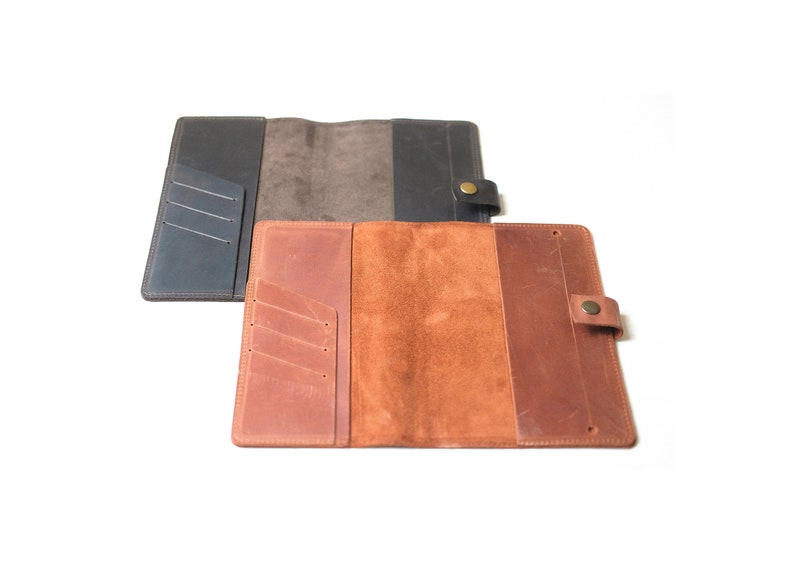 May include: Two leather passport holders, one brown and one black, with multiple card slots and a snap closure.